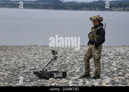 A Sailor assigned to Explosive Ordnance Disposal Mobile Unit (EODMU) 1 observes a Mark II Talon remotely operated vehicle (ROV) during a Certification Exercise (CERTEX) on Naval Air Station Whidbey Island in Oak Harbor, Washington, May 22, 2021. The CERTEX qualifies EODMU-1 for operational deployments where they enable fleet and joint forces to execute a full spectrum of military operations. EODMU-1 is a critical part of Navy Expeditionary Combat Force that clears explosive hazards to provide access to denied areas, secures the undersea domain for freedom of maneuver, builds and fosters relati Stock Photo