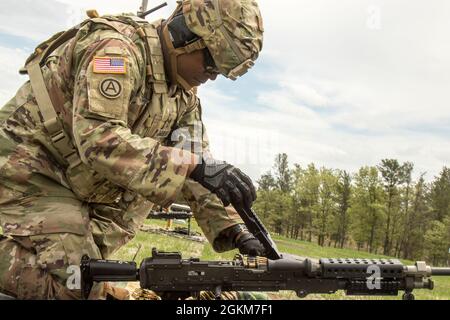 Sgt. 1st Class John Aguilar, a U.S. Army Reserve Drill Sergeant from the 98th Training Division, places a linked belt of 7.62mm NATO ammunition into an M240L General-Purpose Machine Gun at the multiple machine gun qualification event during the 2021 U.S. Army Reserve Best Warrior/Best Squad Competition at Fort McCoy, Wis., May 24. Approximately 80 Soldiers from across the nation travelled to Fort McCoy to compete in the annually-recurring event running May 19-28. It brings in the best Soldiers and squads from across the U.S. Army Reserve to earn the title of “Best Warrior” and “Best Squad” amo Stock Photo