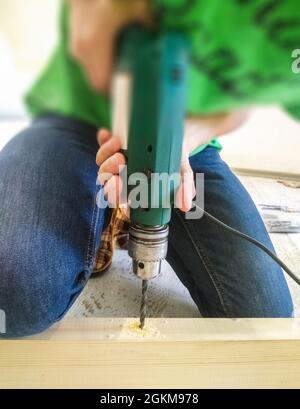 Repairman during maintenance work holding a drill Stock Photo