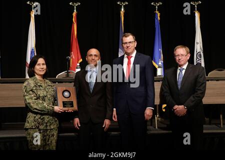 Paul Walter, manager of Naval Information Warfare Center Atlantic‘s Architecture, Requirements & Modeling (ARM), center left, accepts a 2021 Department of the Navy (DON) Information Technology (IT) Excellence Award May 24 during the DON IT Conference, East Coast, at the Hilton Norfolk The Main, in Norfolk, VA. Walter won in the “Workforce” category for his contributions as the Technology Focus Area Champion for Model Based Systems Engineering (MBSE). Presenting the award are DON Chief Information Officer Aaron Weis, center right; DON Cyber Security Division Director Rear Adm. Susan BryerJoyner Stock Photo