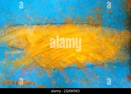 Peeling blue orange paint on a metal surface exposing underlying rusty metal Stock Photo