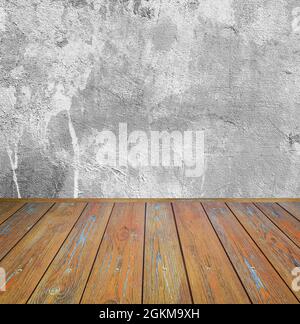 Room interior: grey damaged cement wall with brown wooden floor Stock Photo