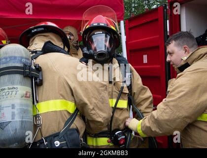 Sailors assigned to the Los Angeles-class fast-attack submarine USS Jacksonville (SSN 699) don firefighting equipment during training with Navy Region Northwest Fire and Emergency Services at Naval Base Kitsap-Bangor in Silverdale, Washington May 25, 2021. The training assesses Sailors’ ability to conduct integrated hands-on firefighting response procedures while combatting a shipboard casualty in port or under construction activity. Stock Photo