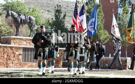 Border Patrol Pipes and Drums leads a multi-agency color guard during the ceremony held by the Big Bend Area Law Enforcement Officers Association on May 26, 2021, on the campus of Sul Ross State University in Alpine, Texas. The horse statue titled, 'Donde Esta? (Where is he)', is a sculpture by Curtis Fort which sits upon a platform with the names of fallen Big Bend region officers who died in the line of duty. All three components of U.S. Customs and Border Protection were represented with personnel from Border Patrol, Office of Field Operations and Air and Marine Operations. Stock Photo