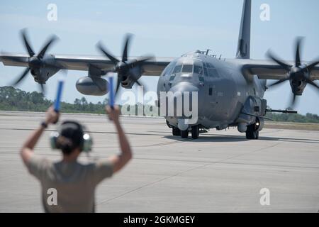 An Airman from the 73rd Special Operations Squadron marshals an AC-130J ...
