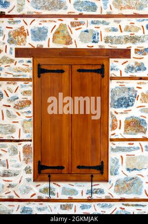 Wooden window shutters closed on aged stone wall Stock Photo