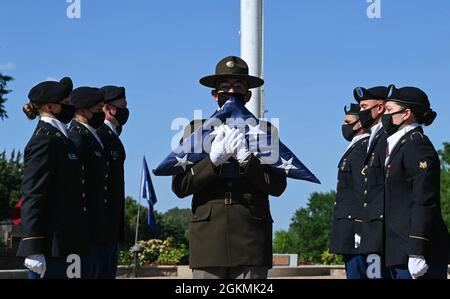 A U.S. Army drill sergeant presents the United States flag after Advanced Individual Training Soldiers lowered and folded it during the Memorial Day retreat ceremony at Joint Base Langley-Eustis, Virginia, May 27, 2021. On Memorial Day, the flag should be flown at half-staff from sunrise to noon and then raised to honor our Nations fallen heroes. Stock Photo