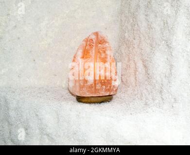 Himalayan orange salt lamp on salty shelf Stock Photo