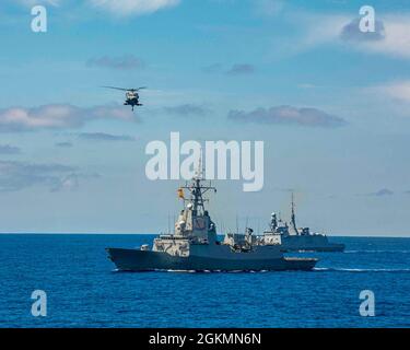 210528-N-EI510-1396 ATLANTIC OCEAN (May 28, 2021) An MH-60 Sea Hawk helicopter attached to the “Dragon Whales” of Helicopter Sea Combat Squadron (HSC) 28 flies over the Spanish Alvaro de Bazan-class frigate Mendez Nunez (F 104) as seen from the Blue Ridge-class command and control ship USS Mount Whitney (LCC 20) during a photo exercise in the Atlantic Ocean, May 28, 2021, in support of the NATO-led joint multilateral exercise Steadfast Defender 2021. Staff from Joint Force Command Norfolk (JFCNF), and U.S. Second Fleet (C2F), as the maritime Component Command (MCC), are charged with employing Stock Photo