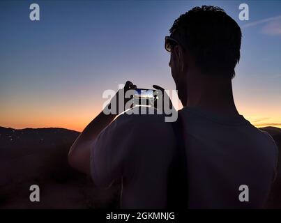 Photographing the sunset with a SmartPhone near Frigiliana,  Malaga Province, Andalucia, Spain Stock Photo
