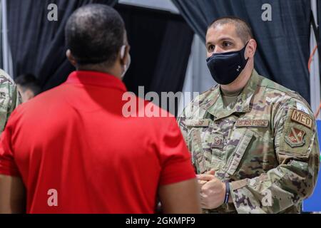 U.S. Air Force Master Sgt. Ryan Powers (right), assigned to 335th Air Expeditionary Group, briefs Prince George's County Councilman Mel Franklin (left), during a tour at the federally-run pilot community vaccination center in Greenbelt, Maryland, May 28, 2021. U.S. service members from across the country are deployed in support of the Department of Defense federal vaccine response operations. U.S. Northern Command, through U.S. Army North, remains committed to providing continued, flexible Department of Defense support to the Federal Emergency Management Agency as part of the whole-of-governme Stock Photo