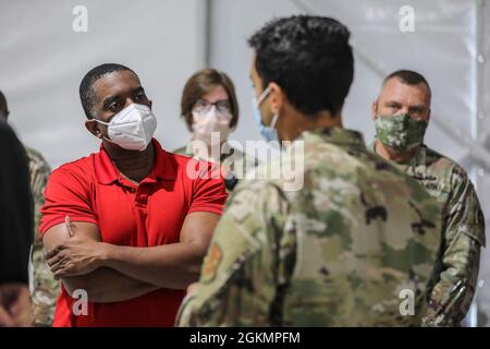 Prince George's County Councilman Mel Franklin (left) speaks with U.S. service members during a tour at the federally-run pilot community vaccination center in Greenbelt, Maryland, May 28, 2021. U.S. service members from across the country are deployed in support of the Department of Defense federal vaccine response operations. U.S. Northern Command, through U.S. Army North, remains committed to providing continued, flexible Department of Defense support to the Federal Emergency Management Agency as part of the whole-of-government response to COVID-19. Stock Photo
