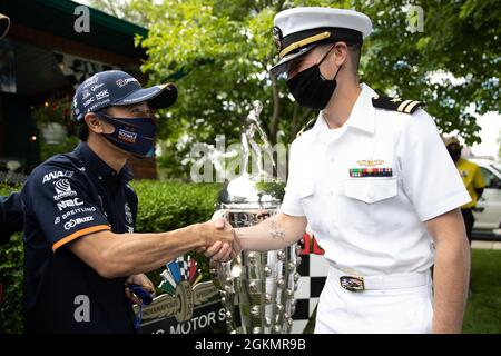 INDIANAPOLIS (May 29, 2021) Lt. Carter Bowman, assigned to the Freedom-variant littoral combat ship USS Indianapolis (LCS 17),  greets the defending Indy 500 champion, Takuma Sato, following the Indianapolis 500 pre-race parade in the ship's namesake city, May 29, 2021.  USS Indianapolis (LCS 17) is homeported at Naval Station Mayport, Fla. Stock Photo