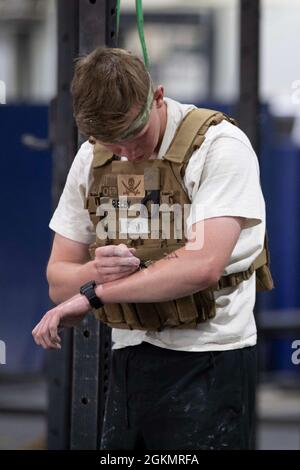 U.S. Army Spc. Owen Belby, a Personal Security Detail agent with U.S. Army Central, tallies his repetitions on his arm during the Memorial Day Murph Challenge at Camp Arifjan, Kuwait, May 29, 2021. Part of the challenge included 100 pull-ups, 200 push-ups, and 300 air squats which participants could split up any way they wanted. Stock Photo