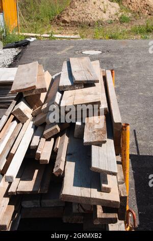 rough wooden boards or slats lie in a pile on a germain construction site Stock Photo