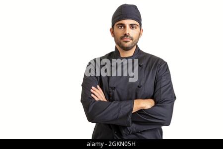 Chef cook in black uniform isolated on white background. Young handsome man with beard and cup standing with crossed hands Stock Photo
