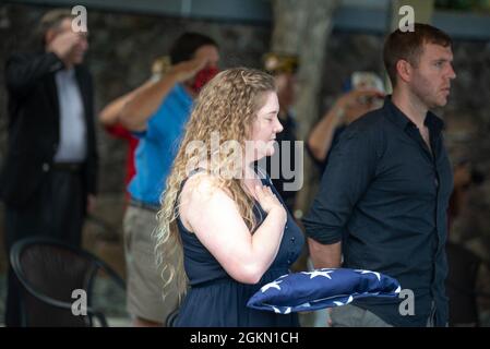 Sarah Adams, great-grandniece of U.S. Navy Gunner’s Mate 3rd Class Shelby Treadway, 25, of Manchester, Kentucky, places her hand on her heart after being presented a flag by sailors assigned to Navy Region Hawaii during her granduncle's funeral at the National Memorial Cemetery of the Pacific, Honolulu, Hawaii, June 2, 2021. Treadway was assigned to the USS Oklahoma, which sustained fire from Japanese aircraft and multiple torpedo hits causing the ship to capsize and resulted in the deaths of more than 400 crew members on Dec. 7, 1941, at Ford Island, Pearl Harbor. Treadway was recently identi Stock Photo
