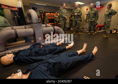 210602-N-IT566-0063 JOINT BASE SAN ANTONIO FORT SAM HOUSTON, Texas (Jun. 2, 2021) (left to right) Hospital Corpsman (HM) 2nd Class Jesse Jenkins, assigned to Navy Medicine Training Support Center (NMTSC), explains the shipboard/platform lab to Rear Adm. Bruce Gillingham, chief of Bureau of Medicine and Surgery and Surgeon General of the Navy, Force Master Chief Michael Roberts, and Rear Adm. Cynthia Kuehner, commander of Naval Medical Forces Support Command during a tour of the Medicine Education and Training Campus (METC) on Joint Base San Antonio Fort Sam Houston. The lab simulates shipboard Stock Photo