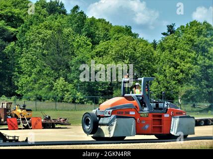 Contractors put down pavement June 2, 2021, on a road near Pine View Campground at Fort McCoy, Wis. The work is part of many types of roadwork taking place on post in 2021. The work is coordinated by the Fort McCoy Directorate of Public Works. Stock Photo