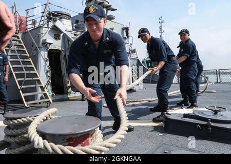 ROTA, Spain (June 5, 2021) Sonar Technician (Surface) 2nd Class Trevor Colley, left, Sonar Technician (Surface) Seaman Peoukinik Than, center, and Sonar Technician (Surface) 3rd Class Jonathan Salas, assigned to the Arleigh Burke-class guided-missile destroyer USS Ross (DDG 71), double up a mooring line as the ship pulls into port in Rota, Spain, June 5, 2021. Ross, forward-deployed to Rota, is on patrol in the U.S. Sixth Fleet area of operations in support of regional allies and partners and U.S. national security interests in Europe and Africa. Stock Photo