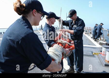 ROTA, Spain (June 5, 2021) Sonar Technician (Surface) 2nd Class Paige Jewett, left, Sonar Technician (Surface) 2nd Class Trevor Colley, center, and Sonar Technician (Surface) 3rd Class Colten Wasden, assigned to the Arleigh Burke-class guided-missile destroyer USS Ross (DDG 71), prepare a pilot ladder to be stowed as the ship pulls into port in Rota, Spain, June 5, 2021. Ross, forward-deployed to Rota, is on patrol in the U.S. Sixth Fleet area of operations in support of regional allies and partners and U.S. national security interests in Europe and Africa. Stock Photo