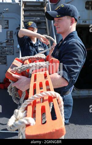 ROTA, Spain (June 5, 2021) Sonar Technician (Surface) 2nd Class Trevor Colley, right, holds a pilot ladder as Sonar Technician (Surface) 2nd Class Paige Jewett helps roll it up aboard the Arleigh Burke-class guided-missile destroyer USS Ross (DDG 71) as the ship pulls into port in Rota, Spain, June 5, 2021. Ross, forward-deployed to Rota, is on patrol in the U.S. Sixth Fleet area of operations in support of regional allies and partners and U.S. national security interests in Europe and Africa. Stock Photo