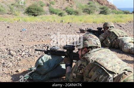 Soldiers assigned to Headquarters and Headquarters Company, 1st Battalion, 102nd Infantry Regiment (Mountain), 86th Infantry Brigade Combat Team zero their assigned M-4 rifle during a zero range in Djibouti, June 6, 2021. Zeroing a weapon creates accuracy, ensuring that the bullet fired from the weapon follows the expected trajectory with the respect to the shooter's line of sight. Stock Photo