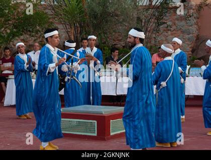 Moroccan dancers perform traditional Berber folk music during a welcome ceremony in  Tafraoute, Morocco for service members on June 6, 2021. African Lion 2021 is U.S. Africa  Command’s largest, premier, joint, annual exercise hosted by Morocco, Tunisia, and Senegal, 7-18 June. More than 7,000 participants from nine nations and NATO train together with a focus on enhancing readiness for us and partner nation forces. AL21 is multi-domain, null-component, and multinational exercise, which employs a full array of mission capabilities with the goal to strengthen interoperability among participants. Stock Photo