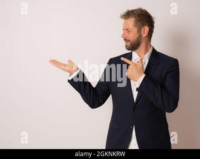 Young handsome business man smiling pointing with two hands and fingers to the side. Stock Photo
