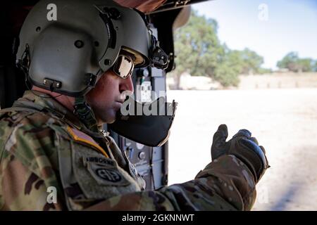 Staff Sgt. Kyle Sanders with Golf Company, 1-189th Aviation Regimen, Oregon Army National Guard takes a brief break during the hot-load portion of a MedEvac training exercise at Fort Hunter Liggett, Calif. June 7, 2021. During the hot-load portion of the exercise, Soldiers are instructed to load a litter onto a stationary UH-60 Blackhawk with blades running while blades are running to simulate a combat environment. Stock Photo