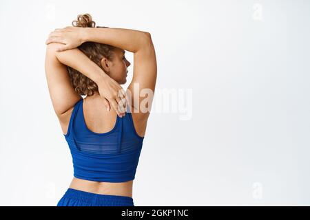 back view of sportswoman doing arms and back extension exercise on lat  machine Stock Photo - Alamy