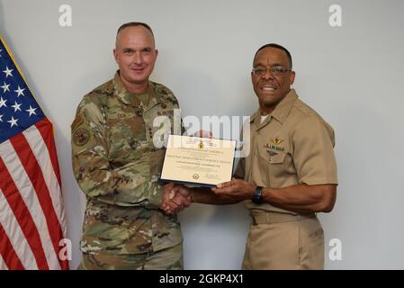 Lt. Gen. Eric Fick, F-35 Joint Program Executive Officer, presents U.S. Navy Capt. Francini Clemmons, F-35 Logistics & Sustainment Military Deputy, with the Defense Meritorious Service Medal certificate during a farewell ceremony at the program headquarters in Arlington, Va. The F-35 Joint Program Office is the Department of Defense's focal point for the 5th generation strike aircraft for the Navy, Air Force, Marines, and our allies. The F-35 is the premier multi-mission, 5th generation weapon system. Its ability to collect, analyze and share data is a force multiplier that enhances all assets Stock Photo