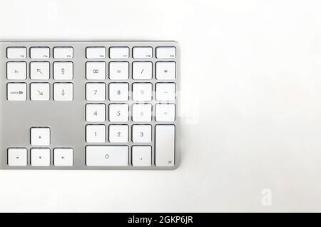Detail of a modern white computer keyboard on a white table. Computer hardware device. Technology and internet Stock Photo