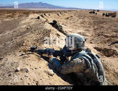 Soldiers with the 548th Transportation Company, Missouri Army National Guard, provide security after being attacked with tear gas, simulating lethal gas, at the National Training Center, Fort Irwin, California, June 11, 2021. The 548th is attached to the 155th Armored Brigade Combat Team whose rotation at NTC builds teamwork and maintains combat readiness for future missions. Stock Photo