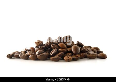 Pile of coffee beans in the center of a white table. Front view. Horizontal composition. Stock Photo