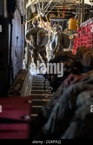 U.S. Army Soldiers with 301st Tactical Psychological Operations, PSYOP, Company (Airborne),14th PSYOP Battalion, 7th PSYOP Group, jump out of a U.S. Air Force KC-130 Hercules during a static-line jump exercise at Naval Base Coronado, California, June 11, 2021. The 301st TCP invited I Marine Expeditionary Force Information Group PSYOP Marines to observe jump training before attending the U.S. Army Airborne school. Gaining jump qualifications enables I MIG to effectively integrate and support I Marine Expeditionary Force information operations in forward deployed environments. Stock Photo