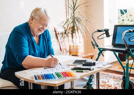 Hobby Ideas for Older People. Retirement Hobbies, Pastimes for Seniors. Activities for Seniors with Limited Mobility. Mature, elderly woman practices Stock Photo