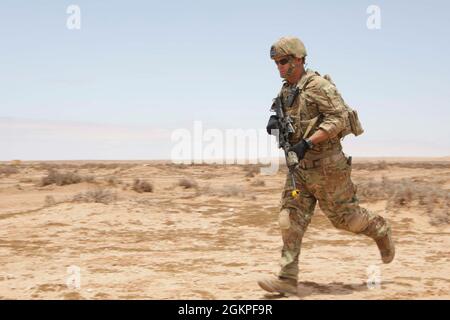 U.S. Georgia Army National Guardsman Sgt. Mark Anderson assigned to Charlie Company, 2nd Battalion, 121st Infantry Regiment, 48th Infantry Brigade Combat Team, Georgia Army National Guard, sprints towards his fighting position at African Lion 2021 in Tan-Tan, Morocco, June 13, 2021. African Lion 2021 is U.S. Africa Command's largest, premier, joint, annual exercise hosted by Morocco, Tunisia, and Senegal, 7-18 June. More than 7,000 participants from nine nations and NATO train together with a focus on enhancing readiness for U.S. and partner nation forces. AL21 is multi-domain, multi-component Stock Photo