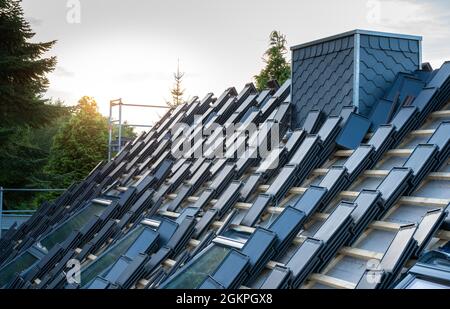 Stacks of new flat tiles on top of a private house. Stock Photo