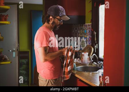 Man washing dishes at home Stock Photo