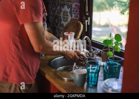 Man washing dishes at home Stock Photo