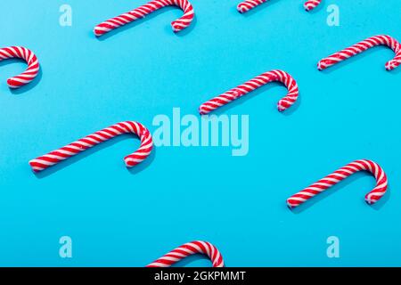 Composition of rows of multiple candy canes on blue background Stock Photo