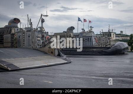 U.S. Marine Corps M142 High Mobility Artillery Rocket System (HIMARS) with Quebec Battery, 3rd Battalion, 12th Marines, 31st Marine Expeditionary Unit (MEU), unloads from a landing craft, air cushion at White Beach, Okinawa, Japan, June 15, 2021. During the exercise Marines conducted simulated fire missions with the HIMARS  by embarking on LCAC’s to quickly deploy precision fire capability on the shore through amphibious landings. The 31st MEU is operating aboard ships of the America Amphibious Ready Group in the 7th fleet area of operations to enhance interoperability with allies and partners Stock Photo