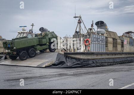 U.S. Marine Corps  M142 High Mobility Artillery Rocket System (HIMARS) with Quebec Battery, 3rd Battalion, 12th Marines, 31st Marine Expeditionary Unit (MEU), unloads from a landing craft, air cushion at White Beach, Okinawa, Japan, June 15, 2021. During the exercise Marines conducted simulated fire missions with the HIMARS  by embarking on LCAC’s to quickly deploy precision fire capability on the shore through amphibious landings. The 31st MEU is operating aboard ships of the America Amphibious Ready Group in the 7th fleet area of operations to enhance interoperability with allies and partner Stock Photo