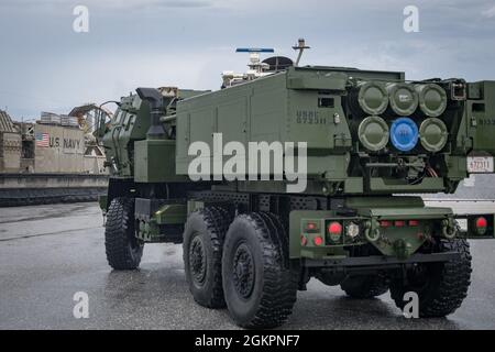 U.S. Marine Corps  M142 High Mobility Artillery Rocket System  (HIMARS) with Quebec Battery, 3rd Battalion, 12th Marines, 31st Marine Expeditionary Unit (MEU), unloads from a landing craft, air cushion at White Beach, Okinawa, Japan, June 15, 2021. During the exercise Marines conducted simulated fire missions with the HIMARS  by embarking on LCAC’s to quickly deploy precision fire capability on the shore through amphibious landings. The 31st MEU is operating aboard ships of the America Amphibious Ready Group in the 7th fleet area of operations to enhance interoperability with allies and partne Stock Photo