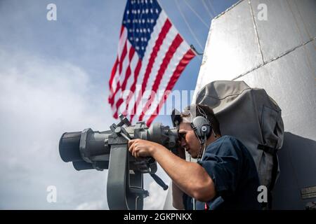 SOUTH CHINA SEA (June 15, 2021) – Seaman Caleb Alba, from Hobbs, N.M., conducts watch stander duties aboard the Arleigh Burke-class guided-missile destroyer USS Halsey (DDG 97). Halsey is attached to Commander, Task Force 70/Carrier Strike Group 5 conducting underway operations in support of a free and open Indo-Pacific. Stock Photo