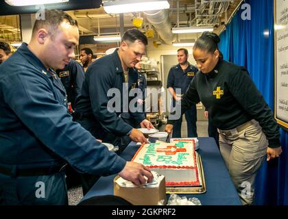 Senior Chief Hospital Corpsman Janae Smart, from East Patchogue, New York, assigned to USS Gerald R. Ford’s (CVN 78) medical department, serves cake during a ceremony honoring the hospital corpsman birthday, June 15, 2021. Ford is underway in the Atlantic Ocean conducting Full Ship Shock Trials (FSST). The U.S. Navy conducts shock trials of new ship designs using live explosives to confirm that our warships can continue to meet demanding mission requirements under the harsh conditions they might encounter in battle. Stock Photo