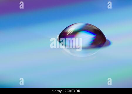 Close up of colorful water drops on a CD, DVD Stock Photo