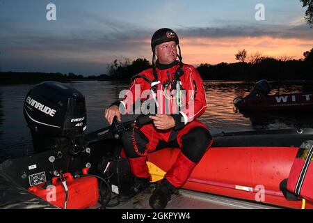 Illinois urban search and rescue Task Force 1 member Andy Hoff sits in a zodiac boat as he prepares to conduct a water search and rescue training mission looking for simulated accident victims in the Mississippi River at La Crosse, Wis., during Exercise PATRIOT 21 June 16, 2021. PATRIOT 21 is a training exercise designed for military members to work alongside civilian emergency management and first responders in the same manner they would during a natural disaster so that in the case of a real-world disaster all agencies can maximize their response efforts, provide necessary resources to the c Stock Photo