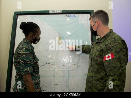 Brazilian Marine Corps (BMC) Cmdr. Gustavo Soares Gomes with BMC  Headquarters is assisted by a U.S. Soldier with 3rd Battalion, 7th Special  Forces Group before parachute training during Tradewinds 2021, Air Station